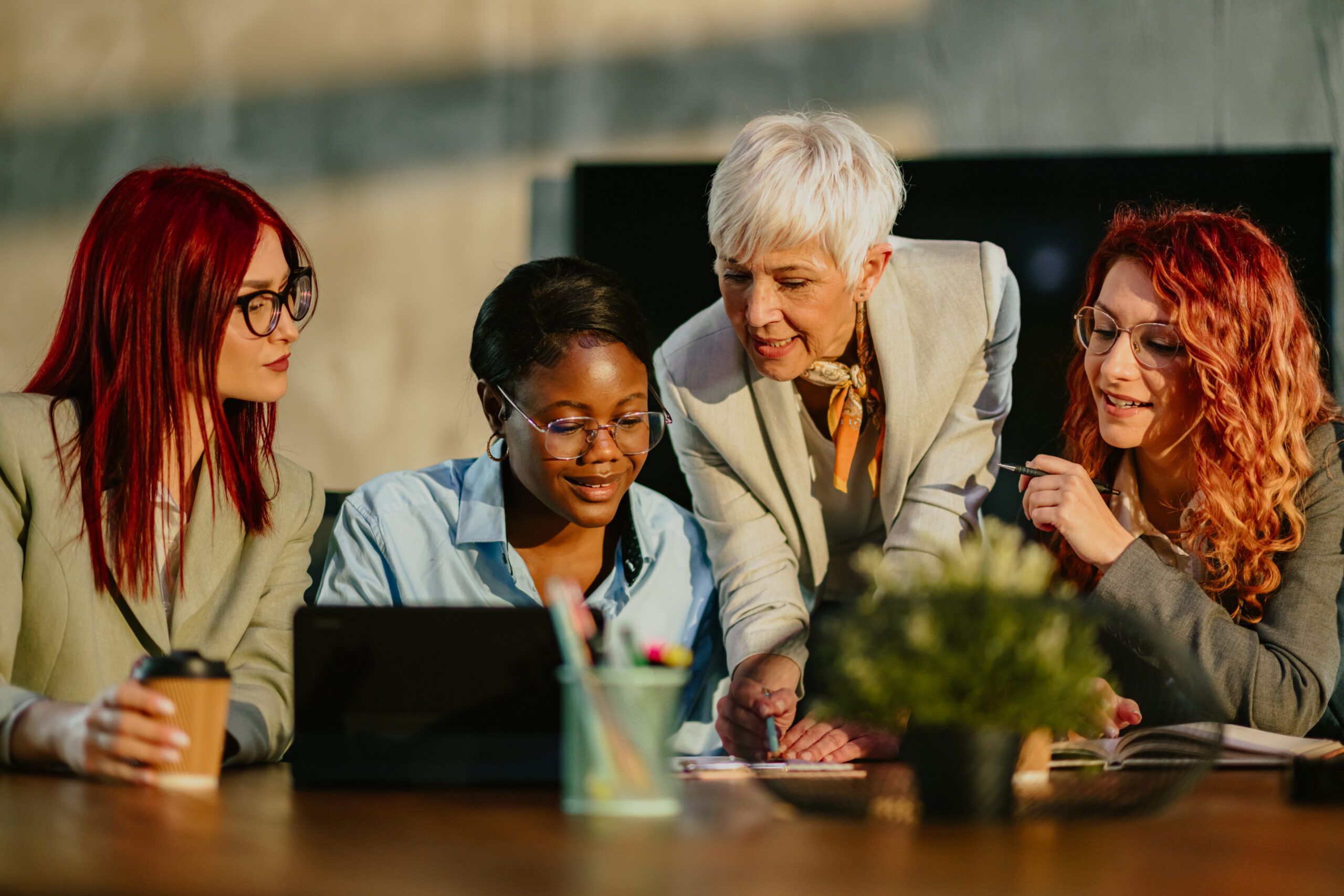 Four women collaborating at a desk.