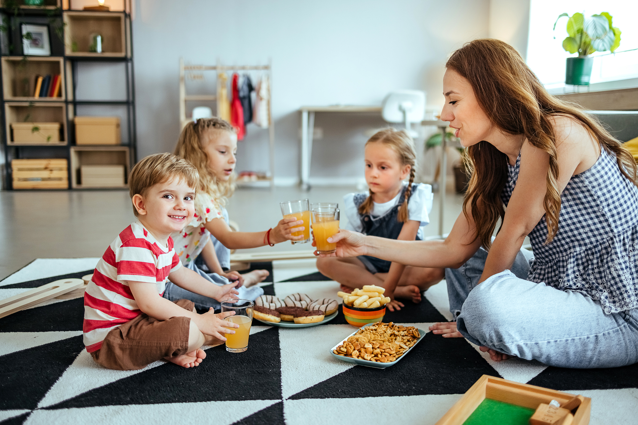 Mother and children have breakfast on the floor.
