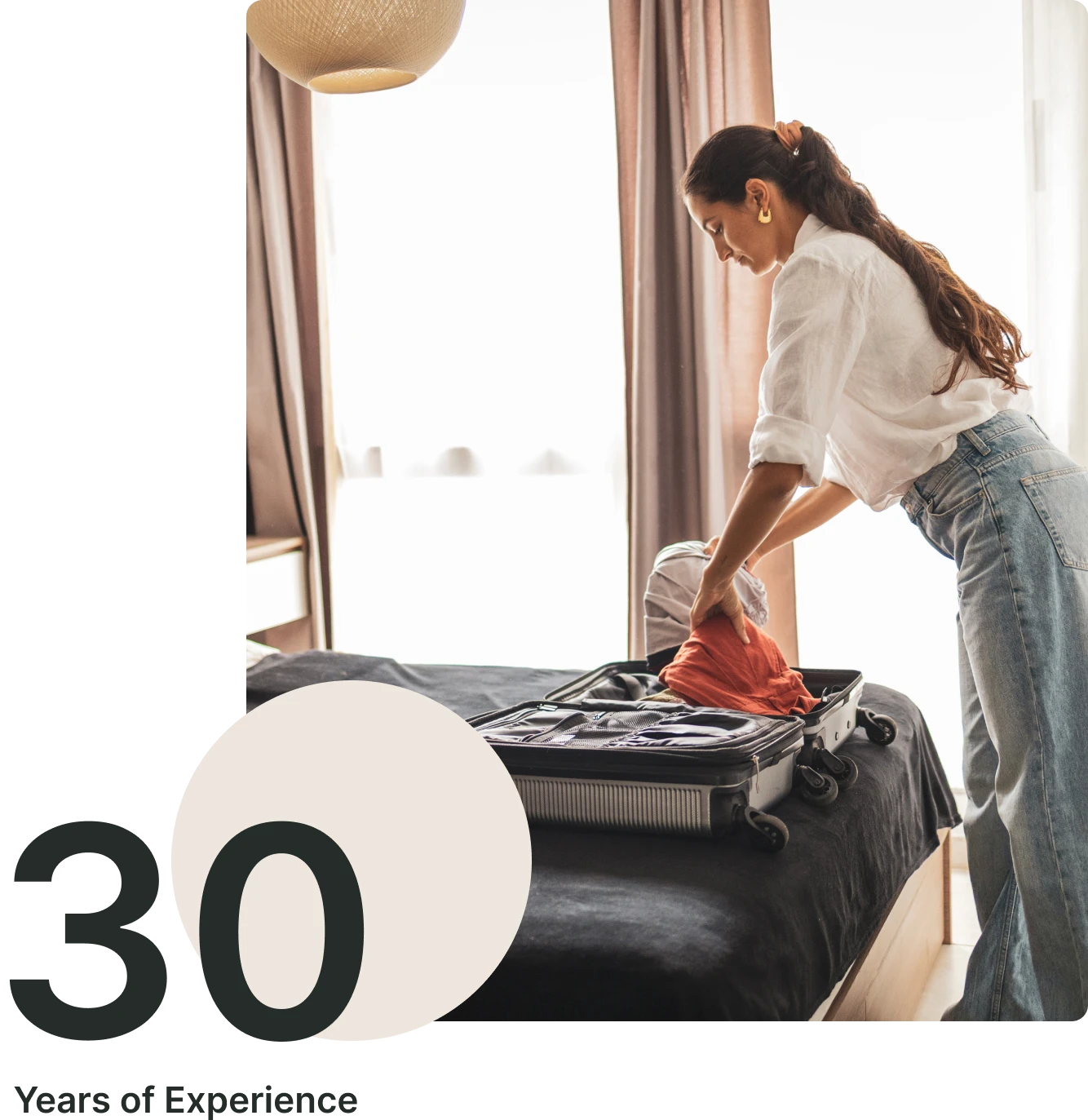 Woman packing suitcase in modern bedroom.