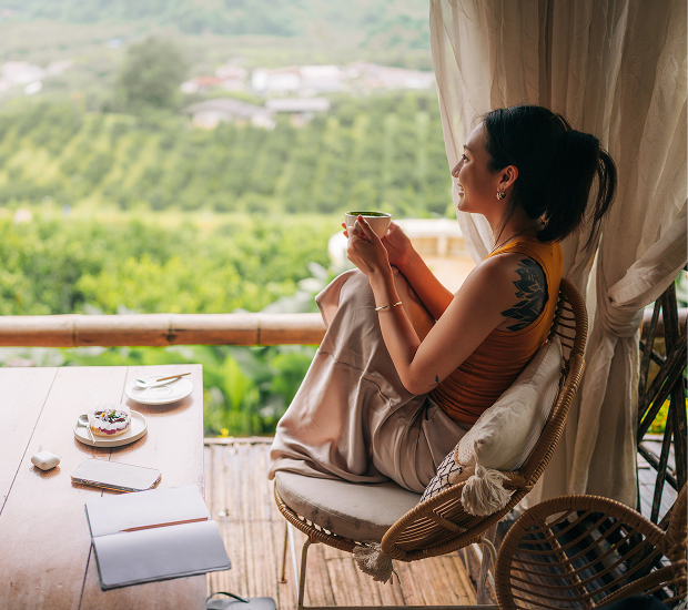 Woman enjoying coffee with scenic view.